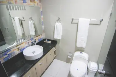 a bathroom with a sink and a toilet and a mirror at Hotel Poblado Coveñas in Coveñas
