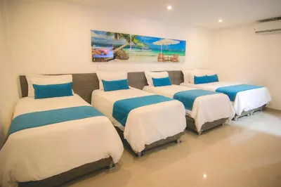 a room with four beds in a room at Hotel Poblado Coveñas in Coveñas