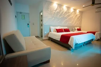 a bedroom with two beds and a couch in it at Hotel Poblado Coveñas in Coveñas