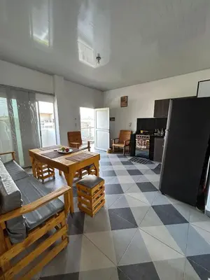 a living room with a table and a kitchen at Amiri in Puerto Colombia