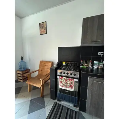 a kitchen with a black stove and a chair at Amiri in Puerto Colombia