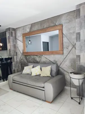 a couch in a living room with a mirror at zara's apartamento en coveñas in Coveñas