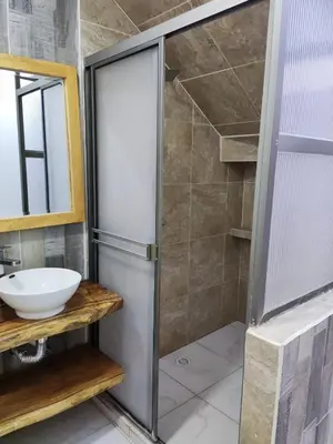 a bathroom with a shower with a sink and a mirror at zara's apartamento en coveñas in Coveñas