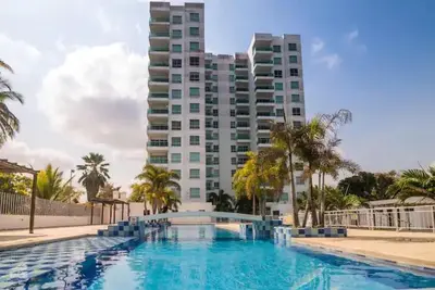 a large swimming pool in front of a tall building at Apartamento con balcon y vista al mar en Coveñas in Coveñas