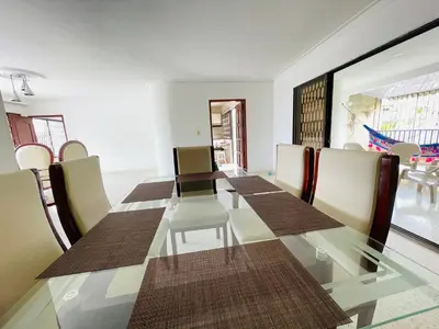 a dining room with a long table and chairs at MADILI DEL MAR in Santiago
