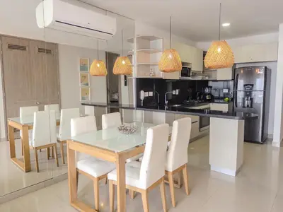 a kitchen with a dining table and white chairs at Oceanview Escape Pool, Jacuzzi & Gym in Bocagrande in Cartagena de Indias