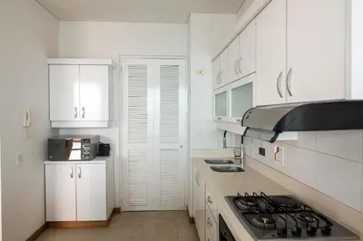 a kitchen with white cabinets and a stove top oven at Magico Apartamento Frente al Mar 3 Habitaciones PAZ151 in Coveñitas