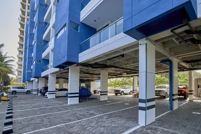 a blue building with cars parked in a parking lot at Magico Apartamento Frente al Mar 3 Habitaciones PAZ151 in Coveñitas