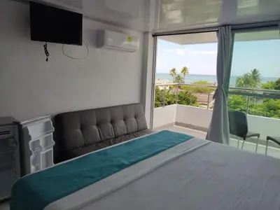 a bedroom with a bed and a view of the ocean at Sky view hotel tolu in Tolú