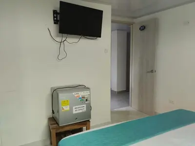 a room with a tv on the wall and a television on a wall at Sky view hotel tolu in Tolú