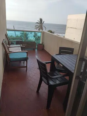 a balcony with a table and chairs and the ocean at Espetacular vista mar y playa in Cartagena de Indias