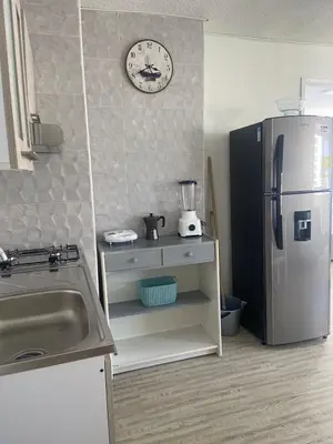 a kitchen with a refrigerator and a clock on the wall at Vista al Mar Fragata Style in Cartagena de Indias