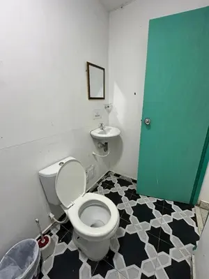 a bathroom with a toilet and a green door at Hotel CastilloMar in Cartagena de Indias