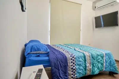 a bedroom with a bed with a blue comforter at Passarela Hospedaje in Cartagena de Indias