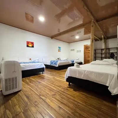 a room with three beds and a fan in it at Cabaña Coral Azul in Playa Blanca