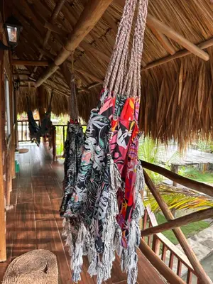 a bunch of clothes are hanging from a thatch roof at Kite Eco House Salinas del rey in Salina de Rey