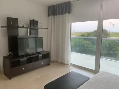 a living room with a tv and a large window at Morros 3 - Vista y salida directa al mar in Cartagena de Indias