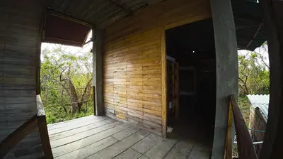 an outside porch of a wooden house with a door at Hotel Paradise in Isla Fuerte