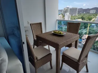 a table and chairs with a bowl of fruit on a balcony at APARTAMENTO BELLO HORIZONTE in Santa Marta