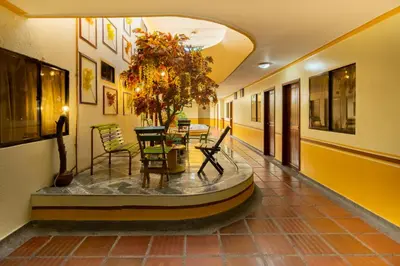 a hallway with a table and chairs and a plant at Hotel Costa mar in Barranquilla