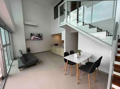 a living room with a table and chairs and a staircase at APTO DUPLEX Bella vista Piscina y buena ubicación in Cartagena de Indias