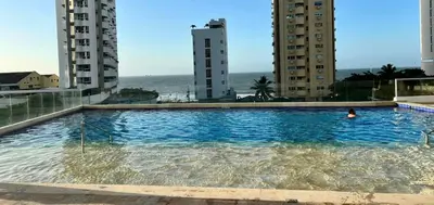 a swimming pool in the middle of two tall buildings at APTO DUPLEX Bella vista Piscina y buena ubicación in Cartagena de Indias