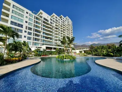 a swimming pool in front of a large building at hermoso apartamento en pozos colorados con playa privada y doble vista al mar in Santa Marta