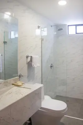 a bathroom with a toilet and a glass shower at Edificio Casa Tabor in Barranquilla