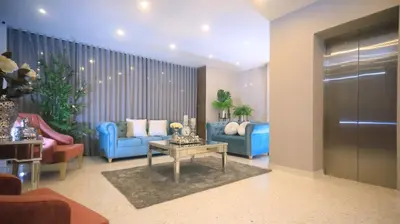 a living room with two blue chairs and a table at Edificio Casa Tabor in Barranquilla