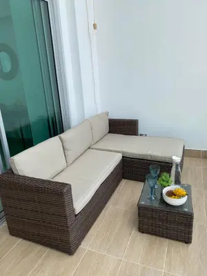 a wicker couch in a living room with a table at New Apartments with great Sunsets near historic center and beach in Cartagena de Indias