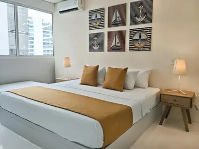a white bedroom with a large bed and a window at Morros 3 Apartamentos de Lujo in Cartagena de Indias