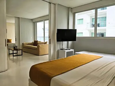 a bedroom with a bed and a tv and a couch at Morros 3 Apartamentos de Lujo in Cartagena de Indias