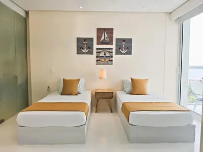 two beds in a room with a window at Morros 3 Apartamentos de Lujo in Cartagena de Indias