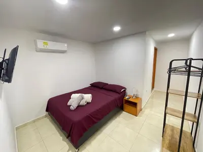 a bedroom with a bed with purple sheets and a ladder at Hotel La Yarolina SAS in Cartagena de Indias
