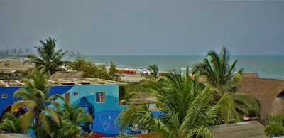 a train traveling past a beach with palm trees at Hotel La Yarolina SAS in Cartagena de Indias
