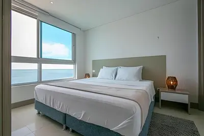 a bedroom with a large bed with a large window at Laurdhomes Palmetto Beach Sea View, for working in Cartagena de Indias