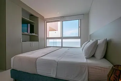 a bedroom with a large bed with a large window at Laurdhomes Palmetto Beach Sea View, for working in Cartagena de Indias