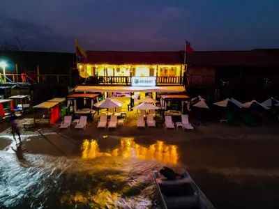 a building with tables and chairs on the beach at night at Gafitas in Playa Blanca