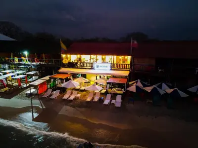 a building with chairs and umbrellas on the beach at night at Gafitas in Playa Blanca