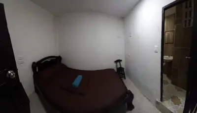 a room with a bed with a blue item on it at HOSTAL EL BALCONCITO in Cartagena de Indias