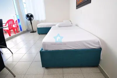 two beds in a room with a table and chairs at apartamento con vista piso 20 in Cartagena de Indias
