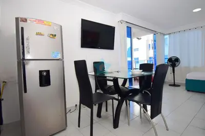 a dining room with a table and a refrigerator at apartamento con vista piso 20 in Cartagena de Indias