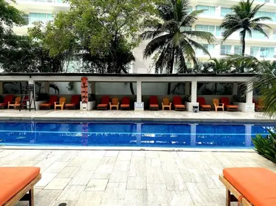 a swimming pool with chairs and a building at Hermoso apartamento familiar /acceso directo a la playa. Morros 3 in Cartagena de Indias