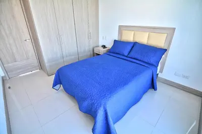 a blue bed with a blue blanket in a bedroom at Toscana Suite 2205 in Cartagena de Indias