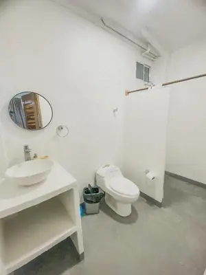 a bathroom with a toilet and a sink and a mirror at Mamallena Beachside Rincon del Mar in Rincón