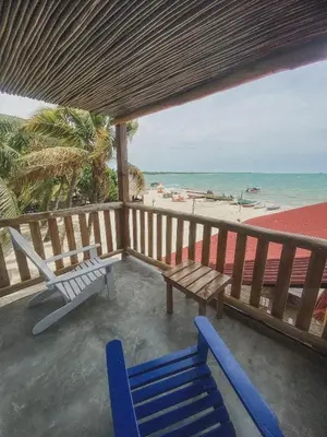 a porch with two blue chairs and the beach at Mamallena Beachside Rincon del Mar in Rincón