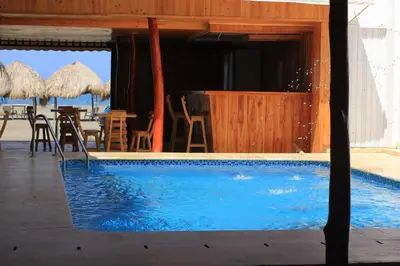 a swimming pool with chairs and tables and umbrellas at Cabaña Yalis SAS in Cartagena de Indias