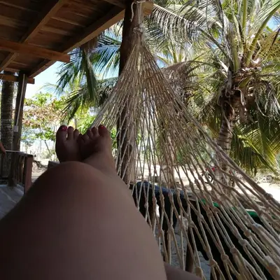 a person laying in a hammock on the beach at LA GAITERA Cabaña in Moñitos