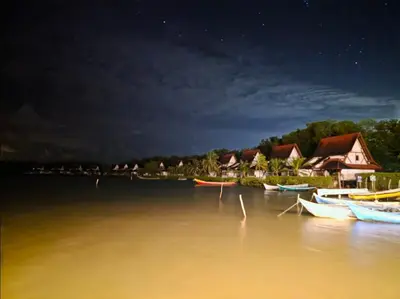 a group of boats in the water at night at PLAYABRISAMAR in San Antero