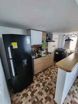 a kitchen with a black refrigerator and a counter at Lujoso apartamento amoblado en Coveñas cerca a la playa in Coveñas